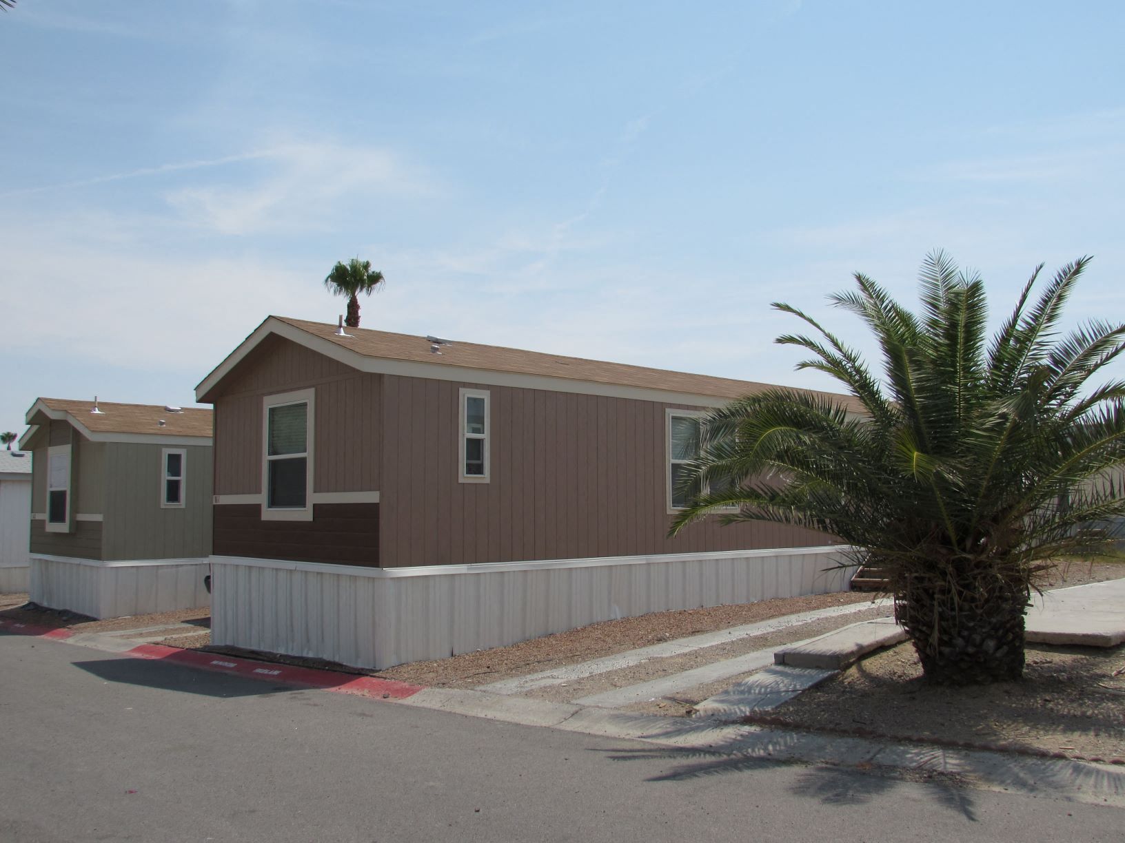 a brown house with a palm tree in front of it